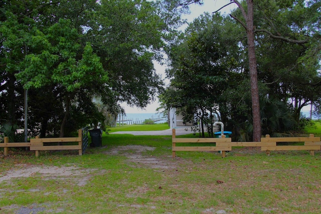 surrounding community featuring a water view and a lawn