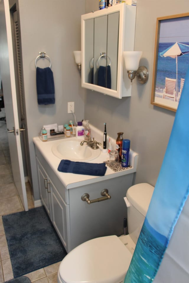 bathroom featuring vanity, tile patterned floors, and toilet