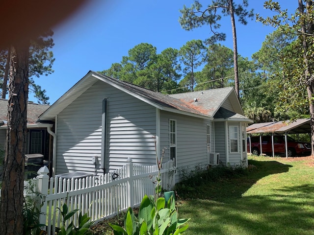 view of side of property with a lawn and a carport