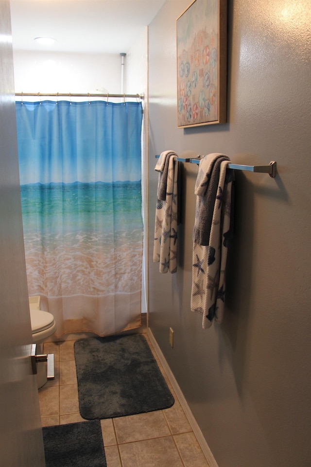 bathroom with a shower with curtain, tile patterned flooring, and toilet