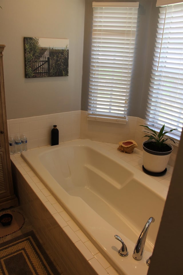 bathroom featuring tiled bath and plenty of natural light