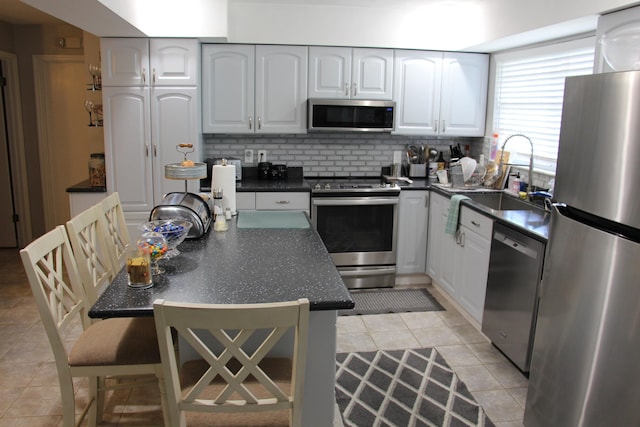 kitchen with white cabinetry, sink, appliances with stainless steel finishes, tasteful backsplash, and light tile patterned floors