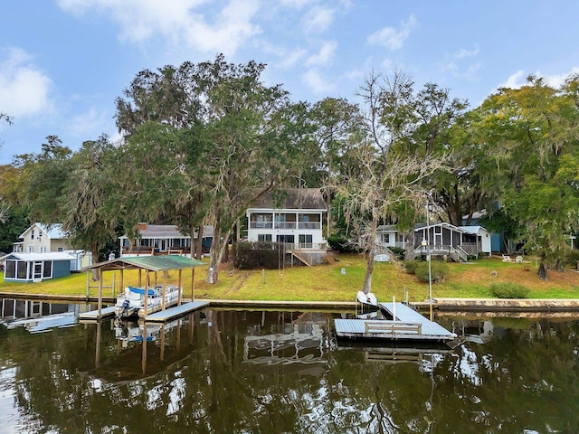 view of dock with a water view and a lawn