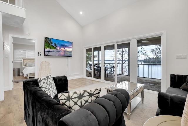 living room featuring light hardwood / wood-style flooring, high vaulted ceiling, and a healthy amount of sunlight