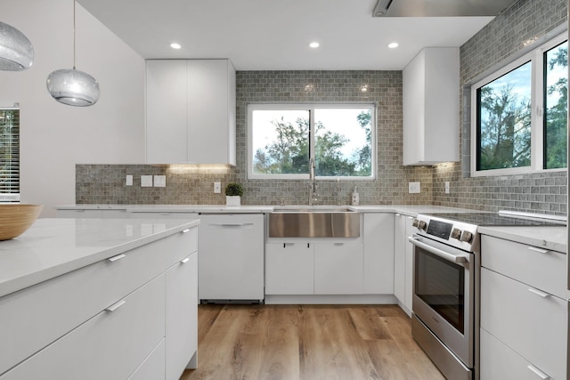 kitchen featuring sink, white cabinetry, decorative light fixtures, electric range, and white dishwasher