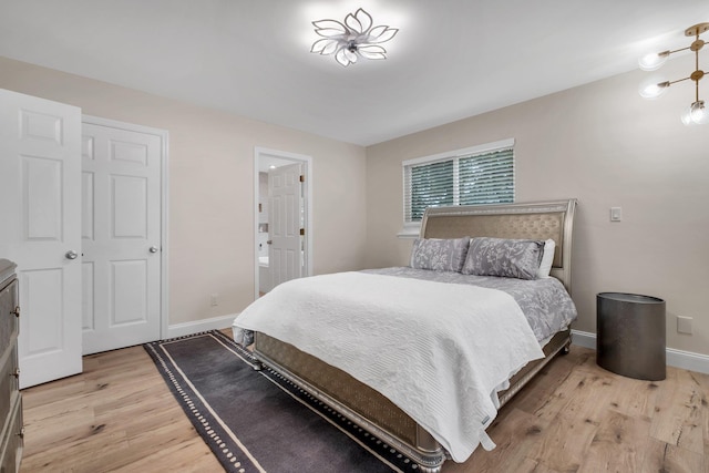 bedroom with connected bathroom and light wood-type flooring