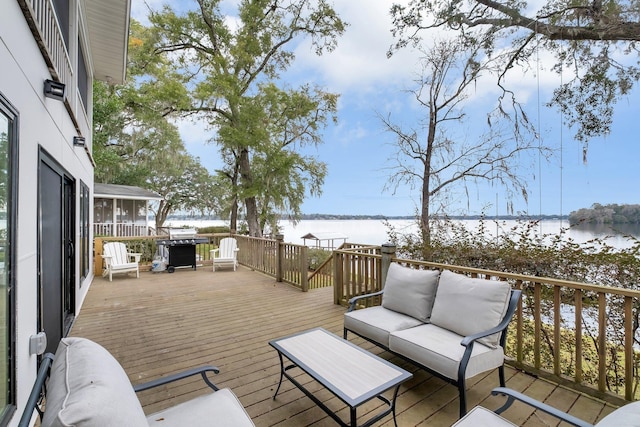 wooden deck featuring a water view, an outdoor hangout area, and grilling area