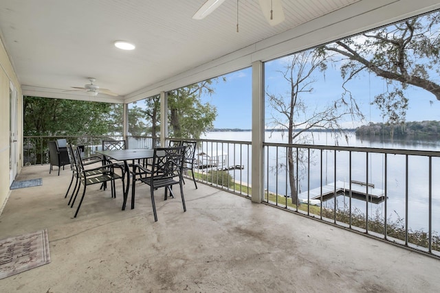 unfurnished sunroom featuring a water view and ceiling fan