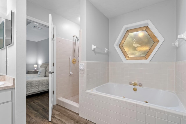 4601 Killimore Ln, Tallahassee, FL 32309 - full bath with connected bathroom, a jetted tub, vanity, walk in shower, and wood finished floors