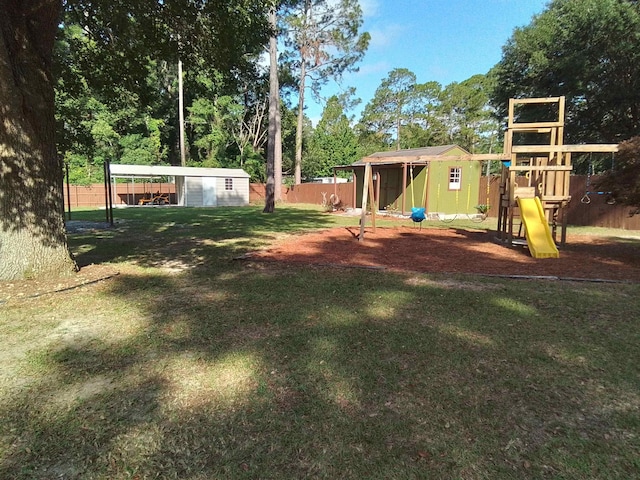 88 Wildwood Dr, Crawfordville, FL 32327 - view of yard featuring a storage unit, a playground, a detached carport, and view of scattered trees
