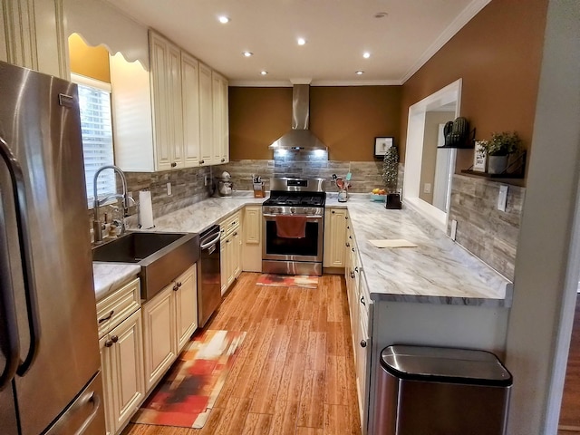 88 Wildwood Dr, Crawfordville, FL 32327 - kitchen featuring appliances with stainless steel finishes, wall chimney range hood, decorative backsplash, light wood finished floors, and crown molding