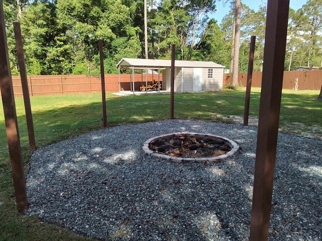 88 Wildwood Dr, Crawfordville, FL 32327 - fenced backyard featuring a fire pit, a patio, and an outbuilding
