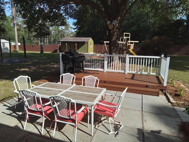 88 Wildwood Dr, Crawfordville, FL 32327 - view of patio / terrace featuring a storage unit, outdoor dining area, a playground, a grill, and a wooden deck
