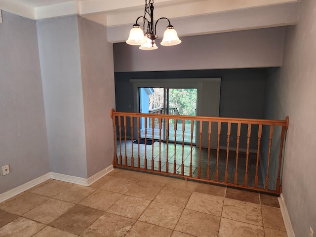 spare room featuring an inviting chandelier