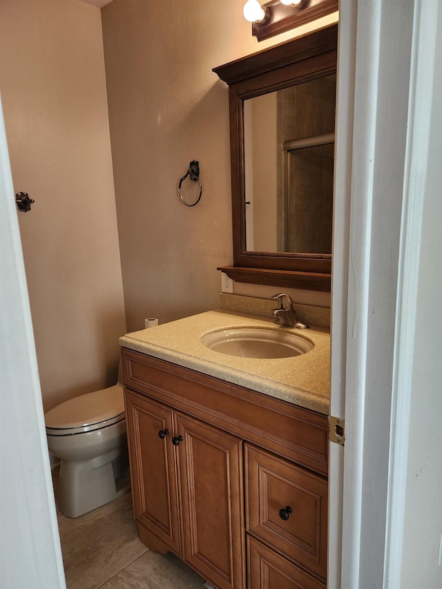 bathroom featuring toilet, vanity, and tile patterned flooring