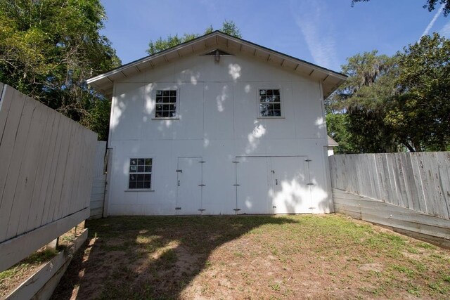 view of side of home featuring a lawn and an outdoor structure