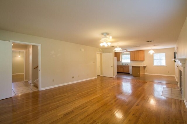 unfurnished living room featuring light wood-type flooring and sink