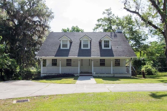 new england style home with a porch and a front lawn