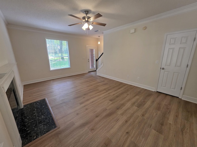 9369 Buck Haven Trl, Tallahassee, FL 32312 - unfurnished living room featuring ornamental molding, wood finished floors, ceiling fan, a fireplace, and stairs