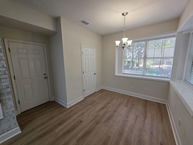 9369 Buck Haven Trl, Tallahassee, FL 32312 - unfurnished dining area with wood finished floors, a textured ceiling, and a chandelier
