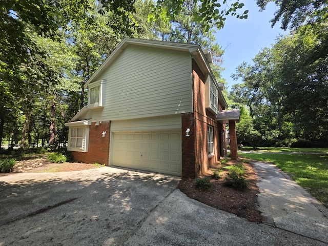 9369 Buck Haven Trl, Tallahassee, FL 32312 - view of side of home with brick siding, an attached garage, and driveway