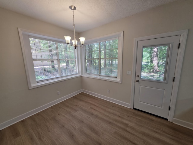 9369 Buck Haven Trl, Tallahassee, FL 32312 - unfurnished dining area featuring dark wood-type flooring, a chandelier, and a textured ceiling