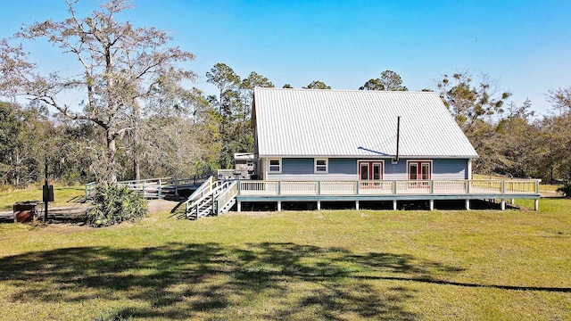 rear view of house with a lawn, a deck, and french doors