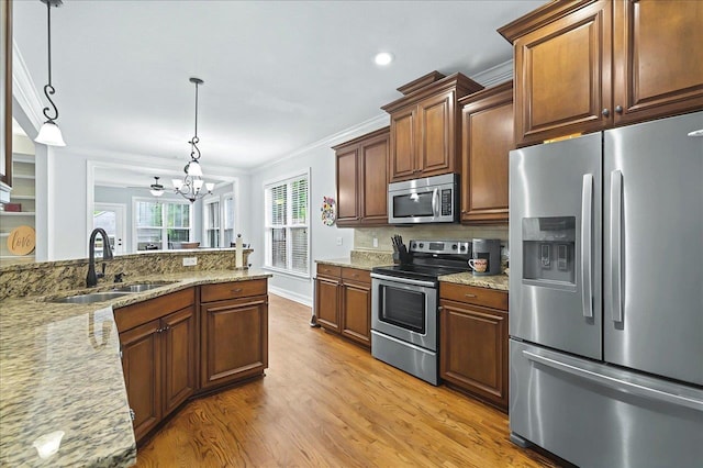 2617 Manassas Way, Tallahassee, FL 32312 - kitchen featuring appliances with stainless steel finishes, ornamental molding, light wood-style flooring, a chandelier, and light stone counters