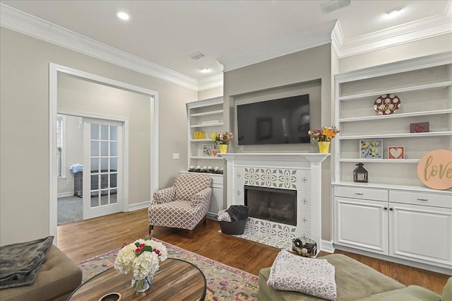 2617 Manassas Way, Tallahassee, FL 32312 - living room featuring dark wood-style flooring, a tile fireplace, crown molding, built in shelves, and recessed lighting