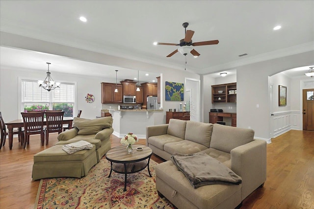 2617 Manassas Way, Tallahassee, FL 32312 - living room featuring ceiling fan, arched walkways, a chandelier, light wood-style floors, and ornamental molding