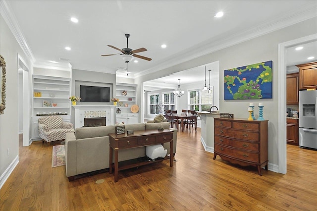 2617 Manassas Way, Tallahassee, FL 32312 - living room featuring a ceiling fan, crown molding, a tiled fireplace, wood finished floors, and recessed lighting