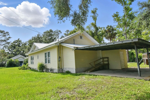 802 N Quincy St, Perry, FL 32347 - view of home's exterior featuring a carport, a yard, and metal roof