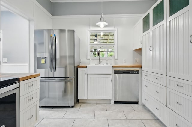 802 N Quincy St, Perry, FL 32347 - kitchen featuring appliances with stainless steel finishes, wood counters, a sink, decorative light fixtures, and light tile patterned floors