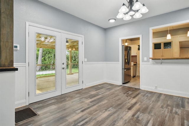 802 N Quincy St, Perry, FL 32347 - unfurnished dining area featuring french doors, wood finished floors, a chandelier, wainscoting, and baseboards