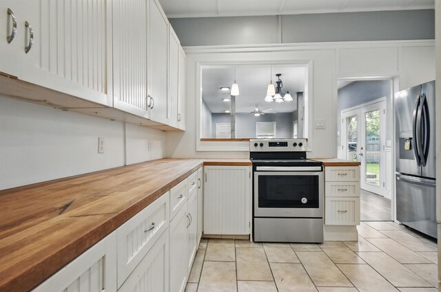 802 N Quincy St, Perry, FL 32347 - kitchen featuring stainless steel appliances, wood counters, light tile patterned flooring, white cabinetry, and pendant lighting