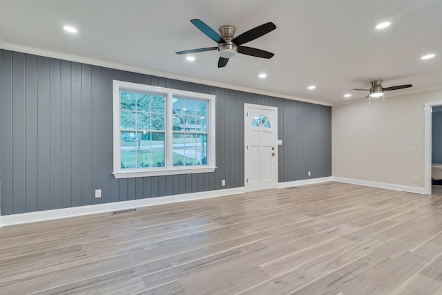 interior space with visible vents, baseboards, ornamental molding, and light wood finished floors