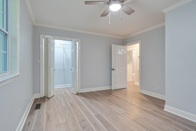 unfurnished bedroom with light wood-type flooring, baseboards, visible vents, and ornamental molding