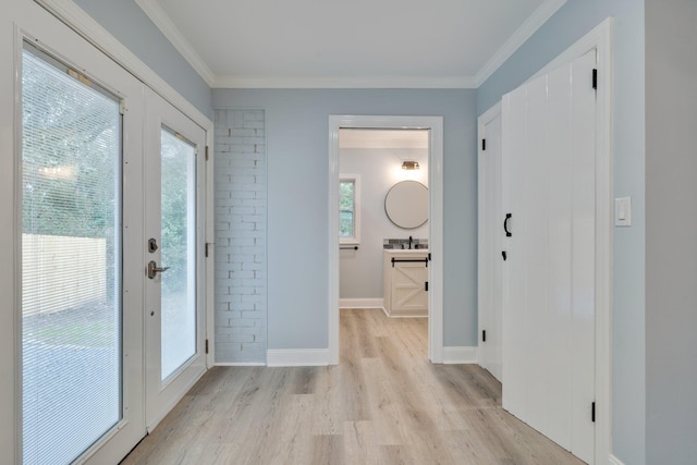 entryway with crown molding, light wood-style floors, and a healthy amount of sunlight