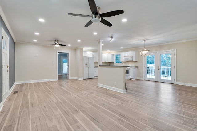 kitchen featuring white appliances, open floor plan, white cabinets, and ornamental molding