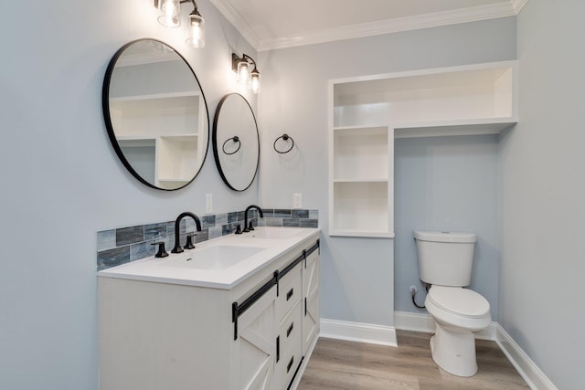 bathroom with ornamental molding, wood finished floors, toilet, and a sink