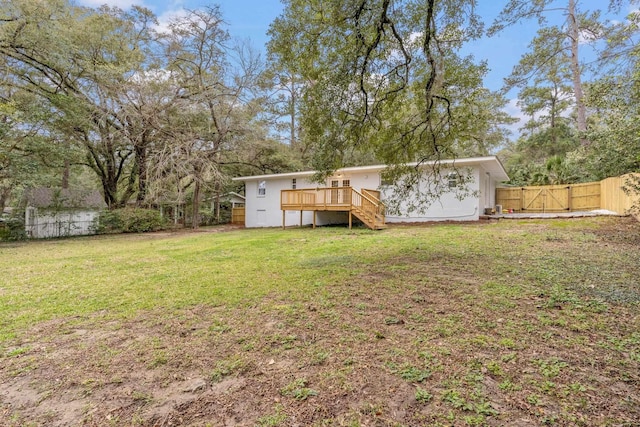 view of yard with a deck, stairway, and fence