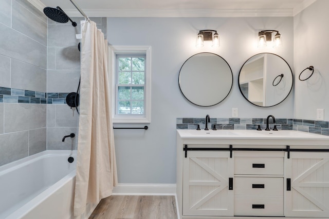 full bathroom with baseboards, double vanity, ornamental molding, wood finished floors, and a sink