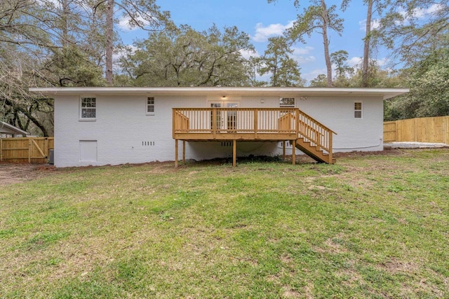 rear view of house with crawl space, a yard, a deck, and fence