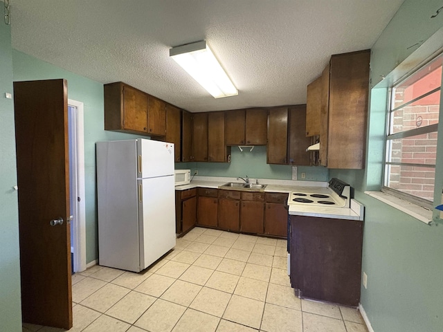 617 Howard Ave, Tallahassee, FL 32310 - kitchen with light tile patterned floors, a sink, light countertops, white appliances, and a textured ceiling