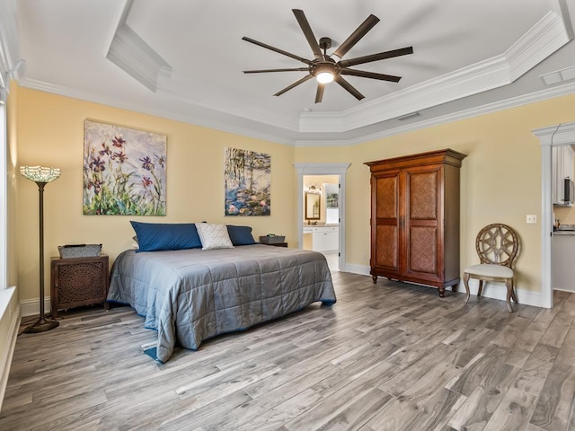 bedroom with a tray ceiling, ornamental molding, and light hardwood / wood-style flooring