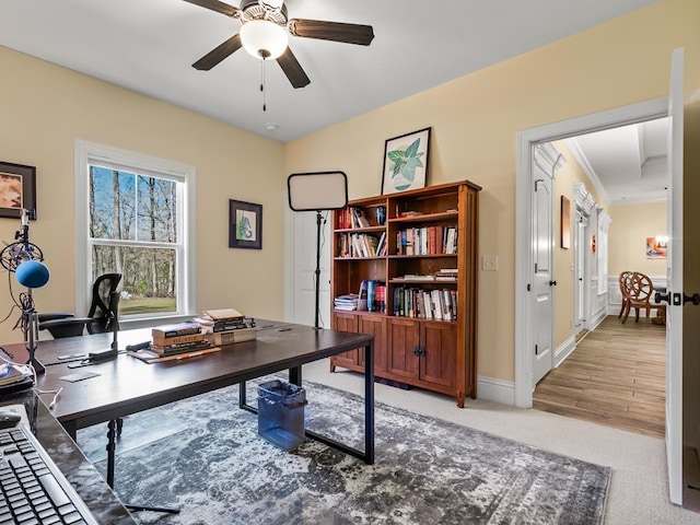 carpeted office featuring ceiling fan