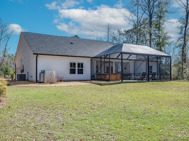 back of property featuring central AC unit, a lawn, a patio area, a lanai, and a jacuzzi