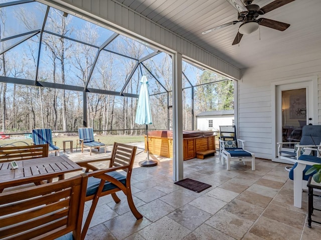 view of patio featuring a hot tub, glass enclosure, and ceiling fan