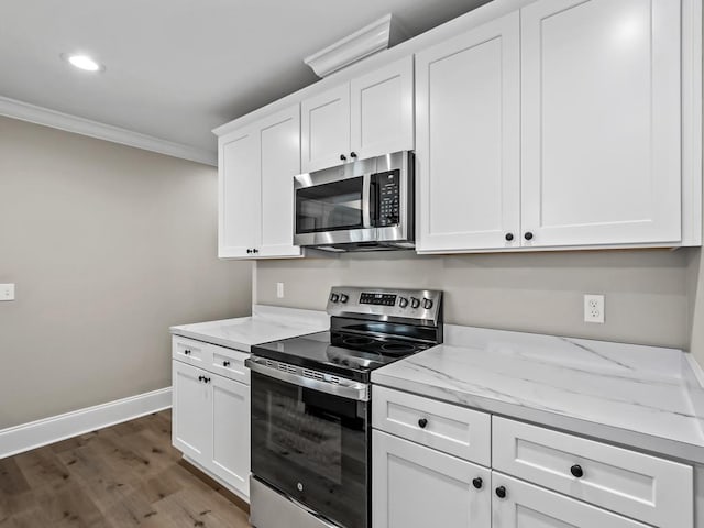 17 Broken Bow Trl, Crawfordville, FL 32327 - kitchen featuring appliances with stainless steel finishes, crown molding, light stone countertops, wood finished floors, and white cabinetry