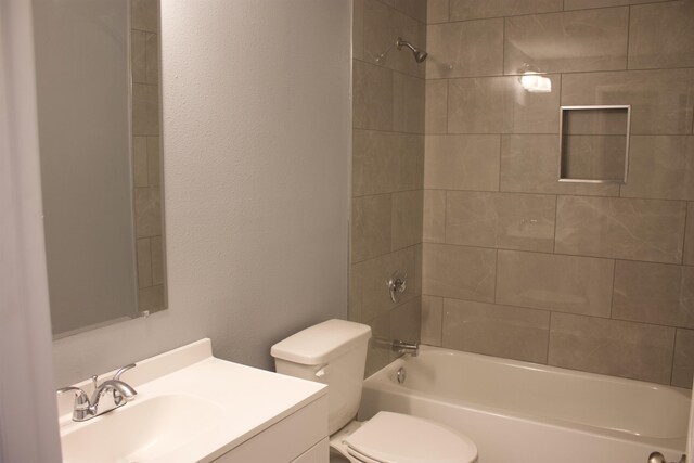 full bathroom with tiled shower / bath, toilet, and vanity